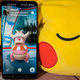 A photo of a smartphone with a screenshot of Pokemon Go laying against a stuffed Pikachu pillow and placed right next to the Switch Pokeball controller